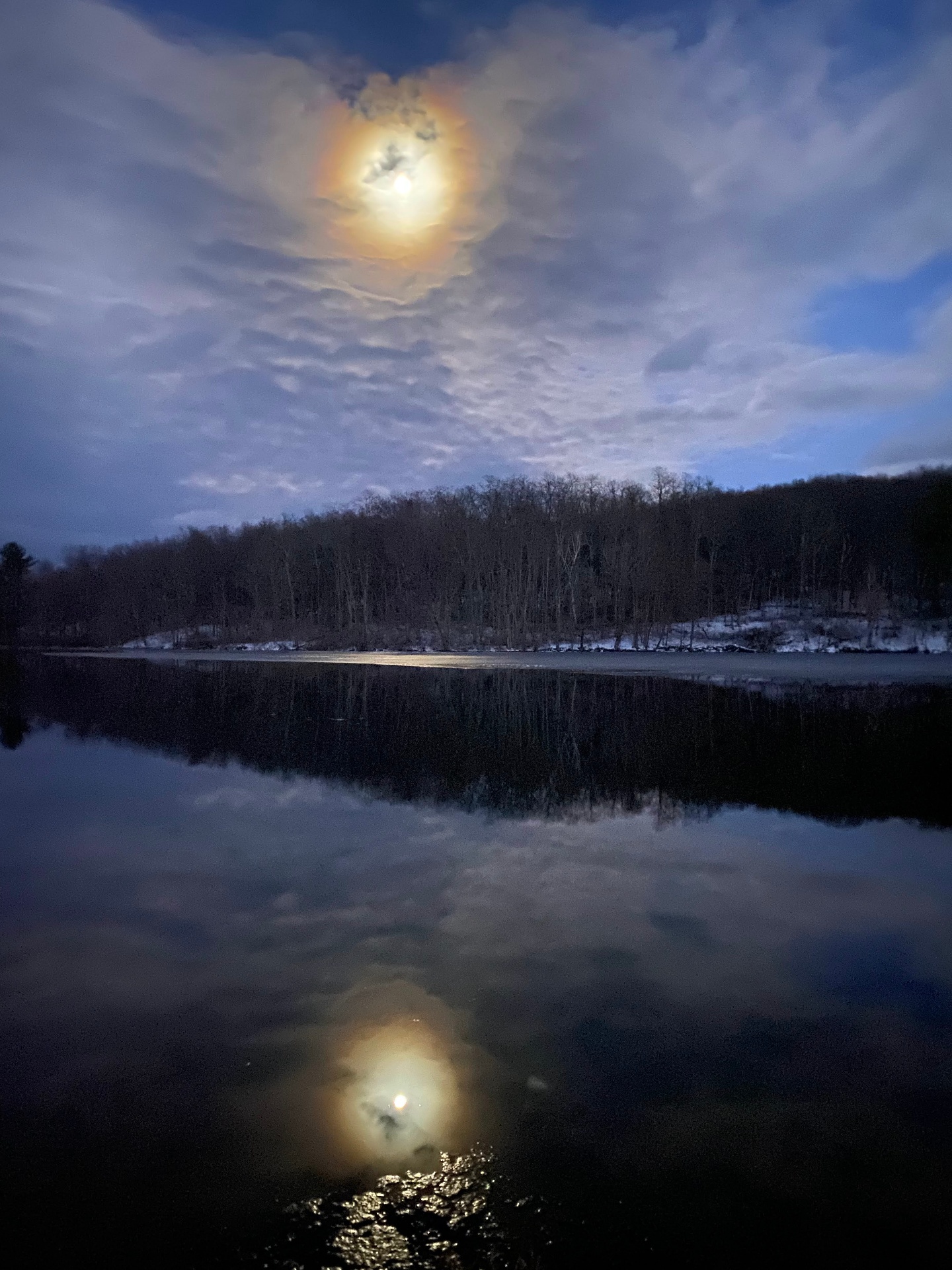 Full moon reflected over a still lake
